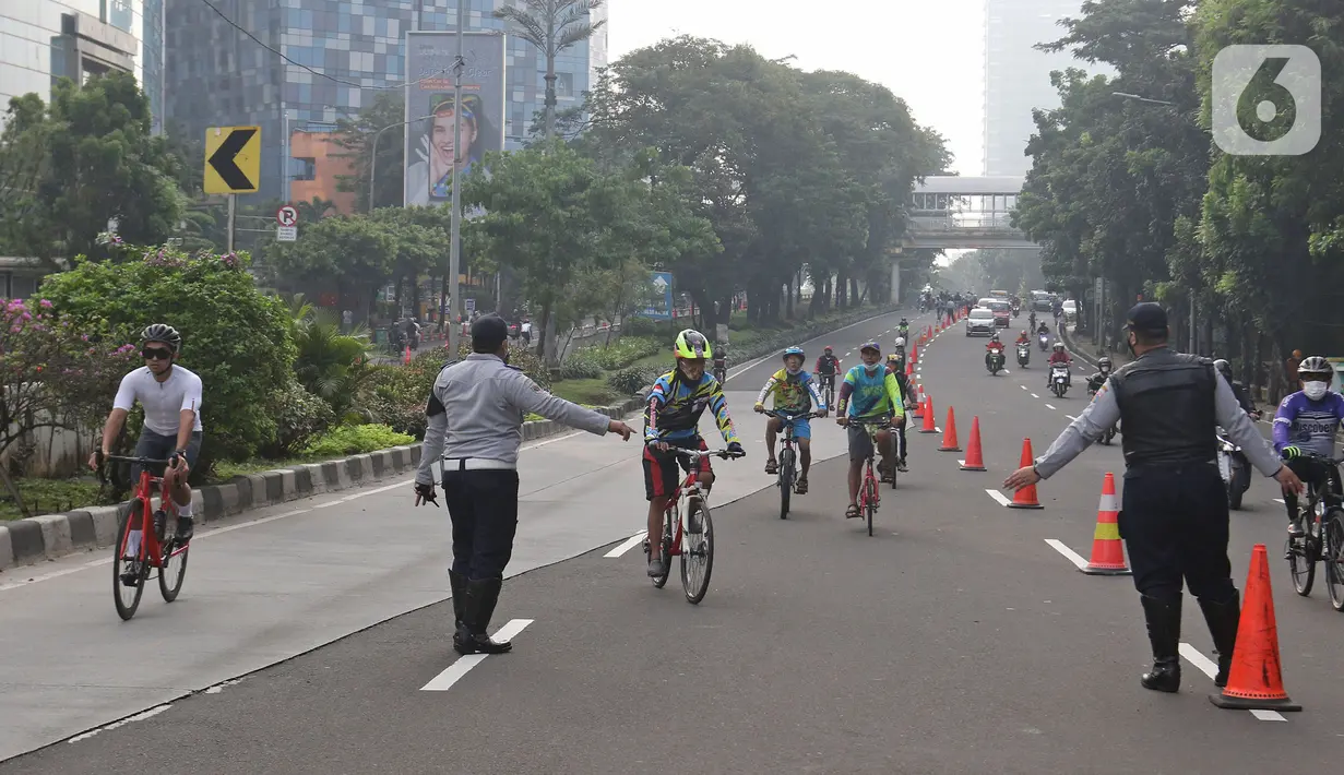 Petugas mengarahakan pesepeda non road bike saat memasuki JLNT Kampung Melayu-Tanah Abang, Jakarta, Minggu (30/5/2021). Dinas Perhubungan DKI Jakarta melakukan uji coba lintasan road bike JLNT Kampung Melayu-Tanah Abang tahap kedua pada pukul 05.00-08.00 WIB. (Liputan6.com/Herman Zakharia)