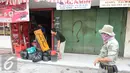 Dua orang warga tampak mengeluarkan barang-barangnya jelang pembogkaran 40 kios yang akan dilakukan oleh Satpol PP di Kavling 36 Pasar Benhil, Jakarta, (29/8/2015). (Liputan6.com/Gempur M Surya)