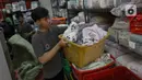 Pekerja penatu mengambil pakaian yang telah selesai dicuci di salah satu tempat layanan penatu di kawasan Ampera Raya, Jakarta, Rabu (17/4/2024). (Liputan6.com/Herman Zakharia)