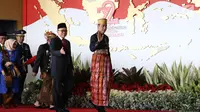 Presiden Jokowi bersama Wakil Presiden Jusuf Kalla didampingi Ketua MPR RI Zulkifli Hasan setibanya di Gedung DPR, Jakarta, Rabu (16/8). Pada sidang tahunan MPR kali ini, Jokowi mengenakan baju adat khas Sulawesi Selatan. (Liputan6.com/Angga Yuniar)
