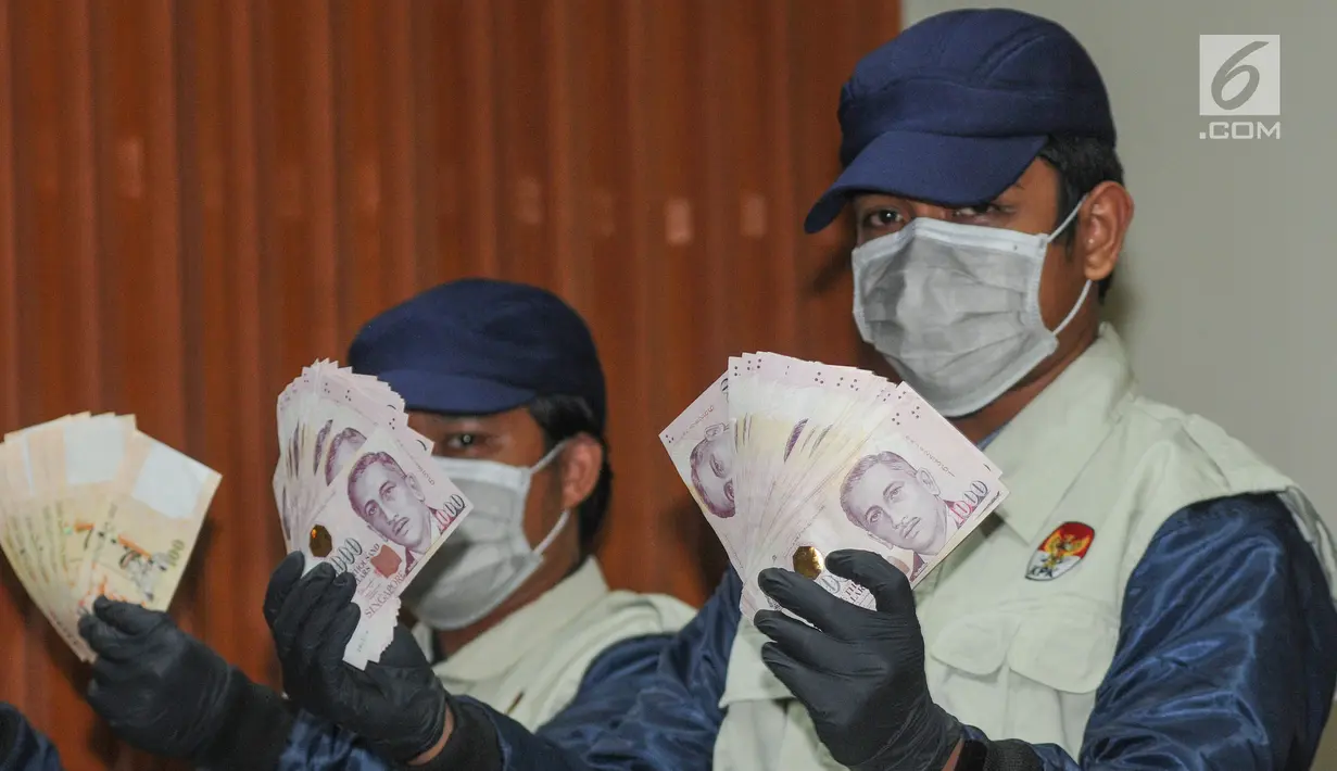 Petugas KPK menunjukkan barang bukti uang SGD 96.700 hasil OTT di Gedung KPK, Kamis (1/8/2019). KPK menetapkan Direktur Keuangan PT Angkasa Pura (AP) II Andra Y Agussalam sebagai tersangka kasus dugaan suap proyek pengadaan baggage handling system (BHS). (merdeka.com/Dwi Narwoko)