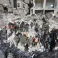 Tim penyelamat Suriah mencari korban dan penyintas yang terjebak di bawah reruntuhan bangunan yang runtuh di Aleppo, Selasa 7 Februari 2023, setelah gempa bumi mematikan yang melanda wilayah tersebut pada hari sebelumnya. Gempa berkekuatan 7,8 SR tersebut terjadi di dekat kota Gaziantep, Turki, menewaskan lebih dari 2.300 orang di Turki dan lebih dari 1.400 orang di negara tetangganya, Suriah. (LOUAI BESHARA/AFP)