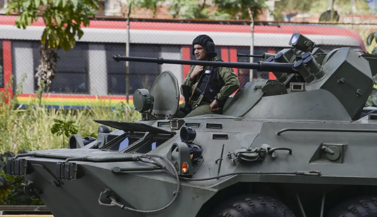 Sebuah tank lapis baja dari tentara Venezuela melewati jalan raya Caracas, Venezuela, Senin (15/1). Dua petugas polisi tewas dalam serangan Oscar Perez ke  kantor Mahkamah Agung (MA) Venezuela. (AFP PHOTO/JUAN BARRETO)