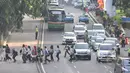 Sejumlah pekerja menyebrang jalan di kawasan Sudirman, Jakarta, Rabu, (22/4/2015). Adanya pengalihan arus untuk KAA membuat mereka terpaksa jalan kaki. (Liputan6.com/Johan Tallo)