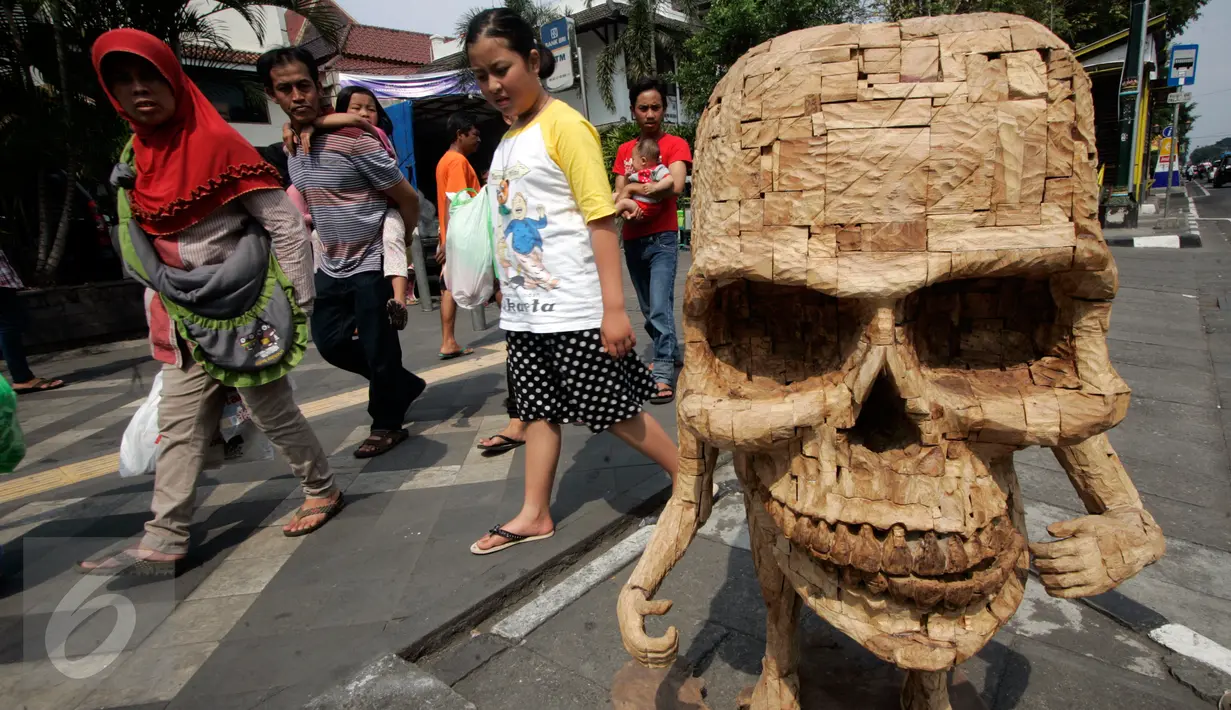 Pengunjung melintasi karya instalasi dari limbah kayu yang menghiasi Jl.Malioboro, Yogyakarta, (5/6).Pameran seni rupa ruang publik di pajang bertujuan  untuk memperindah kawasan Malioboro yang ramai di kunjungi pejalan kaki.(Boy Harjanto)