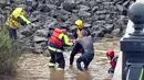 Petugas penyelamat menarik seorang pria dari Sungai Salinas yang berlumpur  saat terjadi banjir bandang di Paso Robles, California (22/3). (KSBY-TV melalui AP)