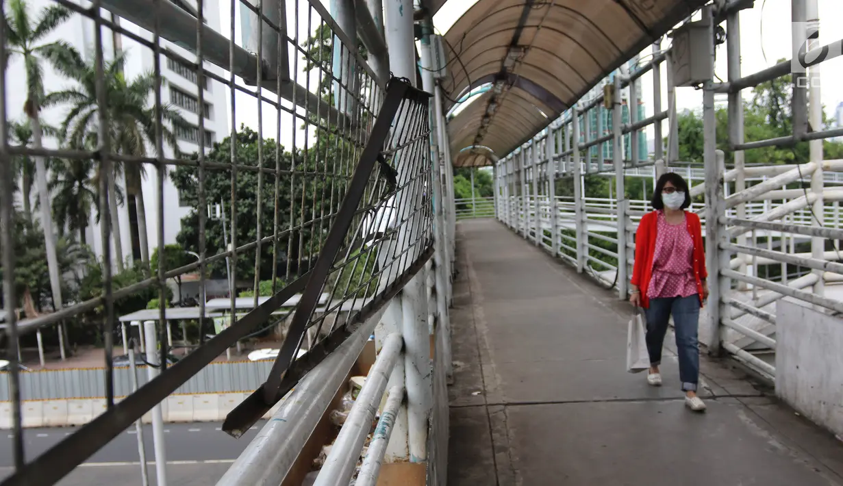 Pejalan kaki melintasi jembatan penyeberangan orang (JPO) di Jalan Sudirman, Jakarta, Jumat (27/4).  Pemprov DKI Jakarta akan merevitalisasi 12 JPO di sepanjang Jalan Sudirman dan Jalan MH Thamrin. (Liputan6.com/Arya Manggala)