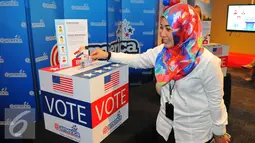 Pengunjung memasukan selembaran voting saat mengikuti simulasi pemilihan Presiden Amerika Serikat di @america di Jakarta, Rabu (9/11). (Liputan6.com/Angga Yuniar)