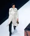 Paula mengenakan trench coat putih dengan monogram khas Vivi Zubedi yang dipadukan dengan celana hitam panjang.  [@vivizubedi].