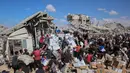 Penduduk Palestina berkumpul di sekitar truk bantuan yang masuk melalui pos perbatasan Karem Abu Salem di Khan Yunis, bagian selatan Jalur Gaza, pada 12 Oktober 2025. (Omar AL-QATTAA/AFP)