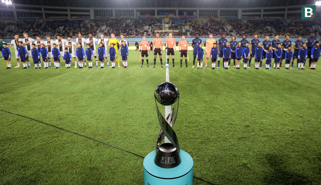 <p>Trofi Piala Dunia U-17 diletakkan di depan dua tim finalis, Timnas Jerman U-17 dan Timnas Prancis U-17 jelang dimulainya laga final Piala Dunia U-17 2023 di Stadion Manahan, Solo, Sabtu (2/12/2023). (Bola.com/Bagaskara Lazuardi)</p>