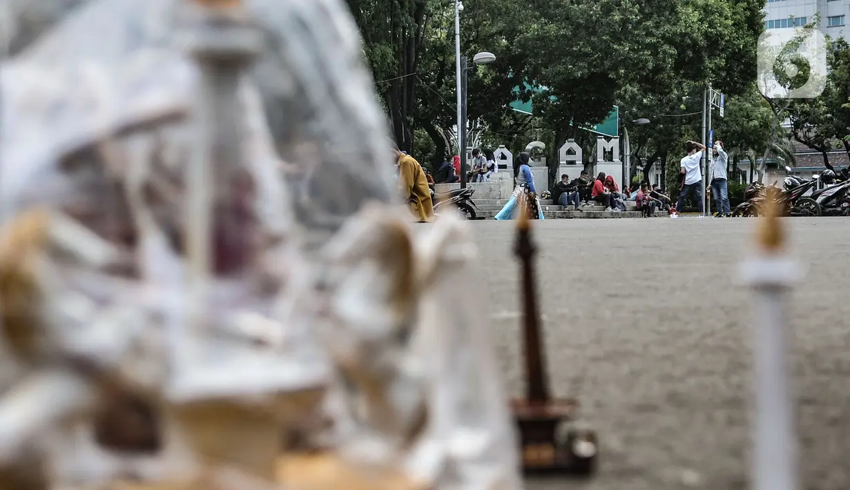 Warga menikmati sore hari di depan gerbang masuk Monumen Nasional (Monas), Jakarta, Minggu (15/11/2020). Meski masih ditutup untuk umum sejak awal pandemi Covid-19, kawasan Monas tetap ramai dikunjungi warga untuk sekadar mengisi akhir pekan. (merdeka.com/Iqbal S Nugroho)