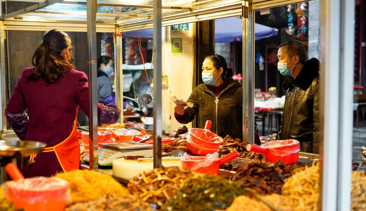 Warga membeli makanan di sebuah kedai di wilayah Xiushan, Chongqing, China barat daya, Jumat (27/2/2020). Kegiatan produksi dan kehidupan sehari-hari warga berangsur normal berkat upaya pengendalian virus corona COVID-19 yang efektif di Xiushan. (Xinhua/Liu Chan)