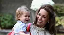 Puteri Cahrlotte rupanya juga senang bermain alat musik loh! Ia tampak bahagia banget dalam gendongan sang ibu. (Getty Images/Cosmopolitan)
