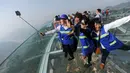 Pengunjung berfoto bersama di atas panggung berlantai kaca yang berada di pinggir tebing di Shilinxia, Beijing, 30 april 2016. Panggung kaca yang menggantung hingga 32.8 meter dari tepi tebing ini merupakan objek wisata baru di China. (AFP PHOTO/STR)