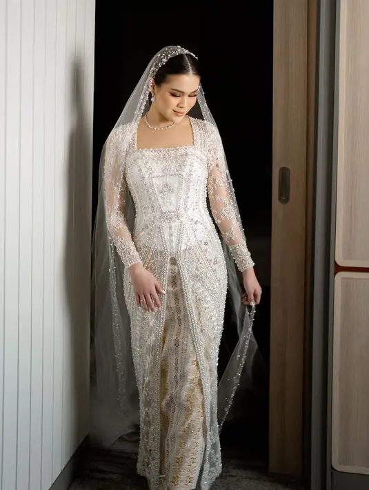 Jadi menantu Hotman Paris, Chen Giovani memilih tampil dengan kebaya brokat putih dari Myrna Myura dipadukan kain songket keemasan saat acara Pemberkataan. Tampilnya tampak modern dengan veilnya. [@chengiovanis.]