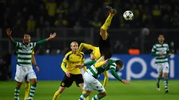 Pemain Borussia Dortmund, Marc Bartra, terjungkal saat berebut bola dengan pemain Sporting CP, Bas Dost, dalam laga Grup F Liga Champions di Signal Iduna Park, Rabu (2/11/2016) waktu setempat. (AFP/Patrik Stollarz)