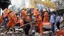 Petugas penyelamat berusaha mencari korban yang tertimbun akibat runtuhnya bangunan di Mumbai, India (31/8). Hampir setiap tahun, puluhan orang tewas akibat bangunan runtuh di India. (AP Photo / Rafiq Maqbool)