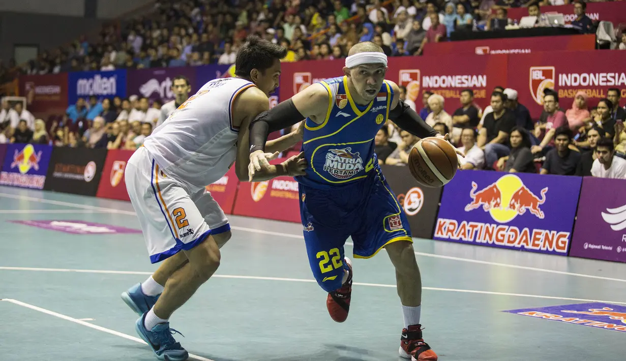 Pebasket Satria Muda, Surawi Vinton, berusaha melewati pebasket Pelita Jaya, Haryoko Dwi, pada laga IBL seri 1 di Hall A Senayan, Jakarta, Sabtu (16/1/2016). (Bola.com/Vitalis Yogi Trisna)