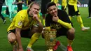 Striker Borussia Dortmund, Erling Haaland (kiri) dan gelandang Jadon Sancho berfoto dengan trofi juara DFB Pokal usai menang 4-1 atas RB Leipzig dalam laga final DFB Pokal 2020/2021 di Olympiastadion, Berlin, Kamis (13/5/2021). (AFP/Annegret Hilse/Pool)