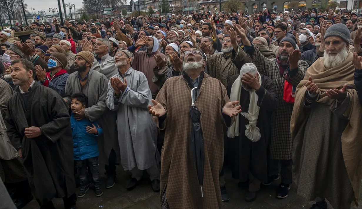 Para pria muslim memanjatkan doa saat imam memamerkan peninggalan Nabi Muhammad pada peringatan Isra Miraj di Masjid Hazratbal, Srinagar, Kashmir, India, Jumat (12/3/2021). Ribuan muslim Kashmir berkumpul di Masjid Hazratbal yang menyimpan janggut Nabi Muhammad. (AP Photo/Dar Yasin)