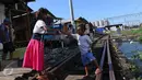 Anak-anak bermain di jalur kereta api di premukiman kampung bandan, Jakarta, Jumat (15/7). Nantinya masing-masing US$ 216,5 juta atau sekitar 2,8 triliun rupiah untuk perbaikan infrastruktur permukiman kumuh di Indonesia. (Liputan6.com/Angga Yuniar)