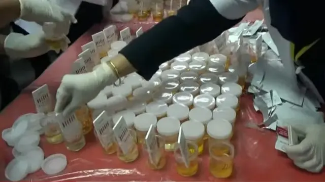 Petugas BNN Riau melakukan tes urine jaksa yang sudah dimasukkan ke wadah kecil.
