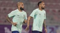 Penyerang Brasil Neymar dan rekan setimnya Dani Alves menghadiri sesi latihan jelang menghadapi Timnas Serbia di stadion Grand Hamad, di Doha, Qatar, Rabu (23/11/2022). Tim Samba konon akan tampil habis-habisan di lini serang demi memetik kemenangan pertama di ajang Piala Dunia 2022 . (AP Photo/Andre Penner)