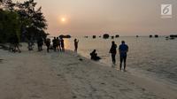 Warga menyaksikan matahari tenggelam (sunset) di Pulau Pari, Kepulauan Seribu, Jakarta pada 3 Agustus 2019. Pulau Pari mempunyai keindahan saat matahari terbenam yang dapat dilihat dari Tanjung Renggae. (Liputan6.com/Herman Zakharia)