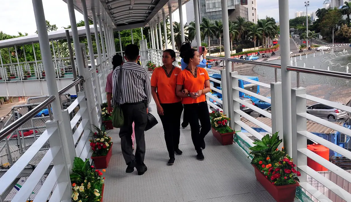 Sejumlah warga melintasi Jembatan Penyeberangan Orang (JPO) yang dihiasi dengan tanaman di Bundaran HI, Jakarta, Rabu (3/12/2014). (Liputan6.com/Johan Tallo)