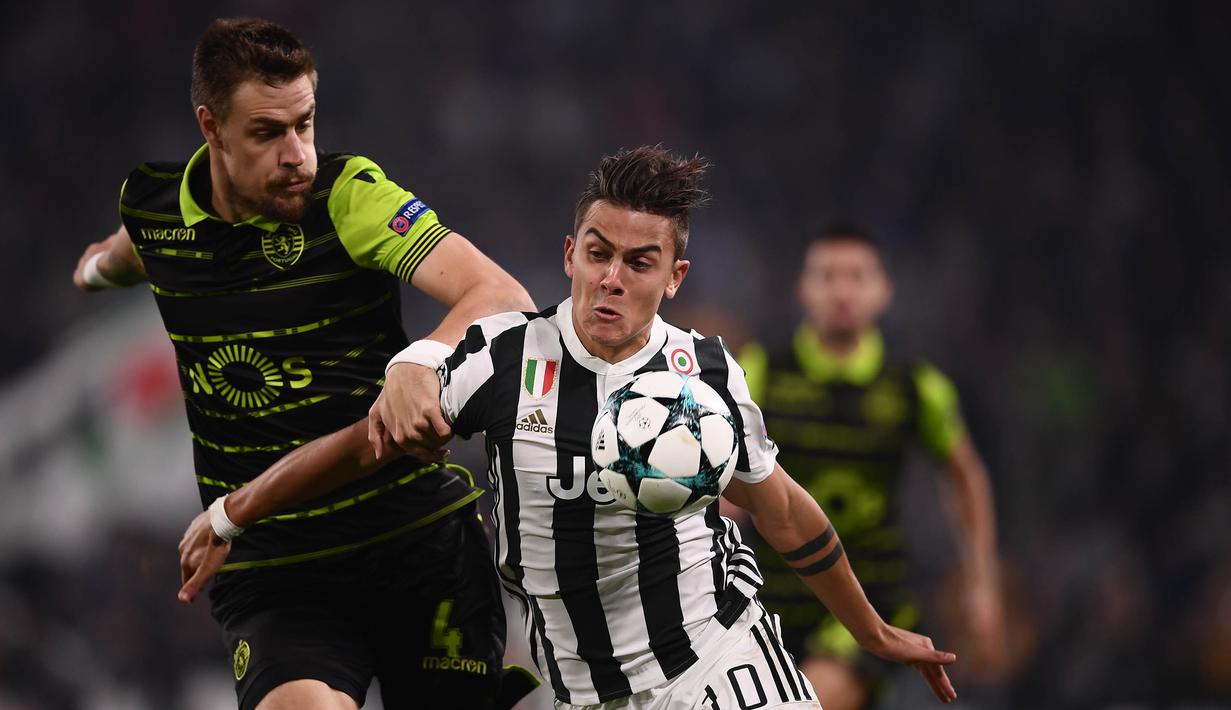 Striker Juventus, Paulo Dybala, berusaha melewati bek Sporting Lisbon, Sebastien Coates, pada laga Liga Champions di Stadion Allianz, Turin, Rabu (18/10/2017). Juventus menang 2-1 atas Sporting. (AFP/Marco Bertorello)