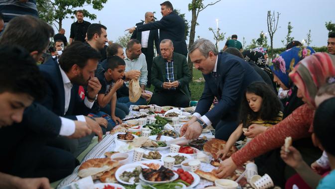 Presiden Turki, Tayyip Erdogan berbuka puasa bersama warga di sebuah taman di Istanbul pada Senin (27/5/2019). Buka puasa bersama tersebut dilakukan Erdogan agar lebih dekat dengan warganya. (Murat Kula/Presidential Press Office/Handout via REUTERS)
