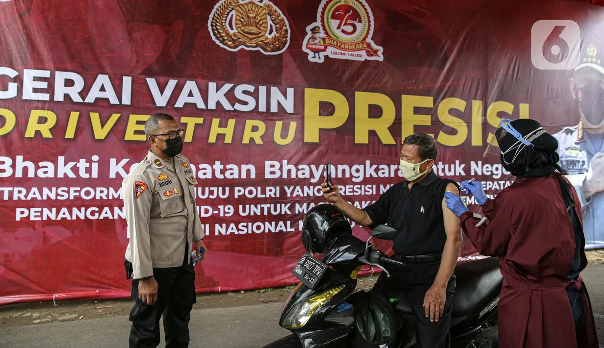 Petugas menyuntikkan vaksin COVID-19 kepada warga saat vaksinasi drive-thru di Mapolres Jakarta Selatan, Selasa (29/6/2021). Polres Metro Jakarta Selatan membuka gerai vaksin presisi dengan menyediakan layanan vaksin COVID-19 gratis kepada warga ber-KTP Jakarta Selatan. (Liputan6.com/Faizal Fanani)