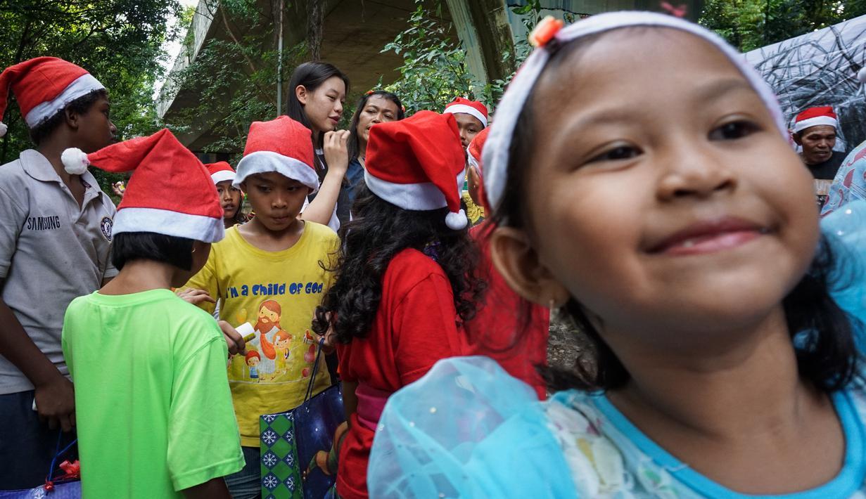 Euclia Purnama kemudian mulai membagikan bantuan untuk para anak-anak. Terlihat keceriaan di wajah mereka. (Bola.com/Bagaskara Lazuardi)