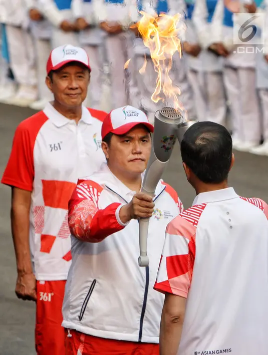 Ketua Inasgoc Erick Thohir saat menyalakan api obor Asian Games 2018 ke Presiden Joko Widodo sebelum upacara penurunan Bendera Merah Putih di Istana Negara Jakarta, Jumat (17/8). (Liputan6.com/Pool/Eko)