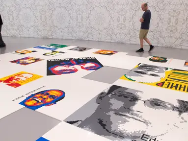 Pengunjung menikmati karya seni gambar bertajuk Ai Weiwei: Trace di Museum Hirshhorn, Washington, AS, 28 Juni 2017. Karya tersebut terdiri dari 176 potret yang disusun dari ribuan batu bata Lego. (AFP PHOTO / PAUL J. RICHARDS)