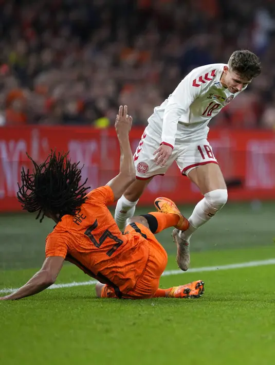 Pemain Denmark Jesper Lindstrom (kanan) berebut bola dengan pemain Belanda Nathan Ake pada pertandingan persahabatan di Johan Cruyff ArenA, Amsterdam, Belanda, 26 Maret 2022. Belanda menang 4-2. (AP Photo/Peter Dejong)