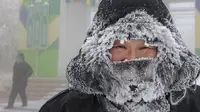 Seorang pria menatap fotografer yang sedang berjalan di jalan saat suhu turun hingga sekitar -50 derajat (-58 derajat Fahrenheit) di Yakutsk, Rusia pada Rusia, Sabtu (16/1/2021).  Yakutsk atau Yakutia tersohor sebagai kota terdingin di dunia. (AP Photo/Ajar Warlamov)