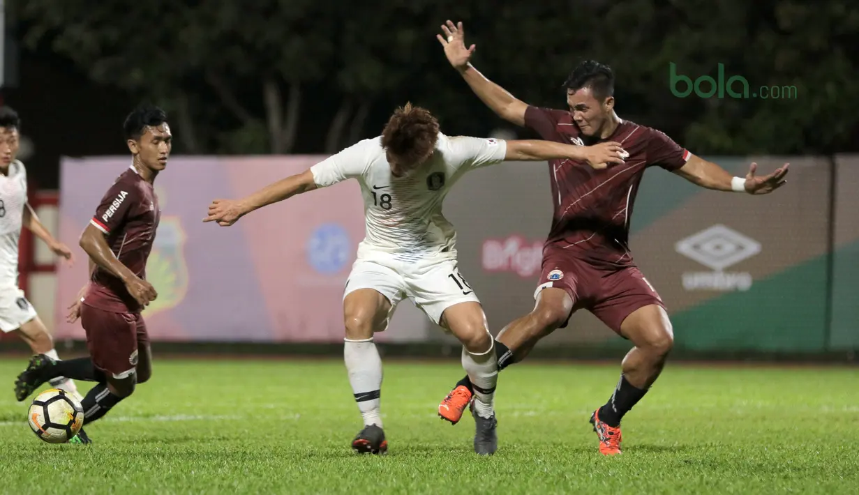 Pemain Korea Selatan U-23, Lee Keun-ho (tengah) mencoba melewati adangan para pemain Persija Jakarta pada laga uji coba di Stadion PTIK, Jakarta, (21/6/2018). Persija kalah 1-3. (Bola.com/ Nick Hanoatubun)