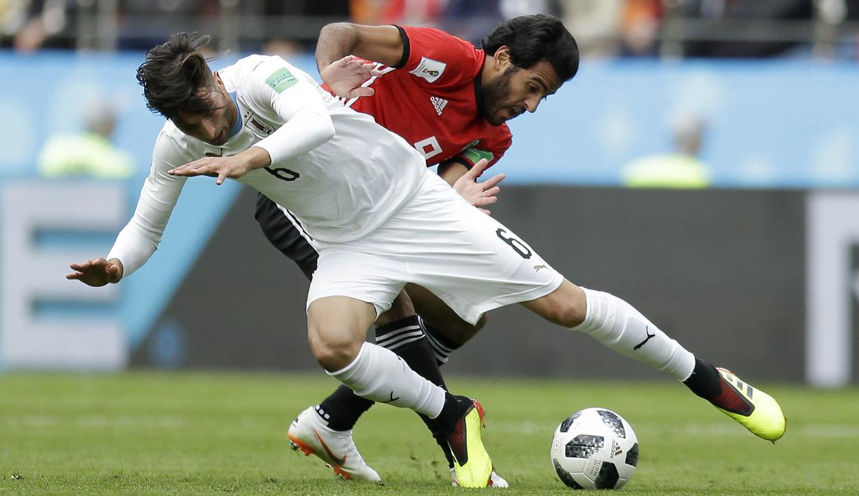 Gelandang Uruguay, Rodrigo Bentancur, berebut bola dengan striker Mesir, Marwan Mohsen, pada laga Piala Dunia di Stadion Ekaterinburg, Jumat (15/6/2018). Uruguay menang 1-0 atas Mesir. (AP/Natacha Pisarenko)