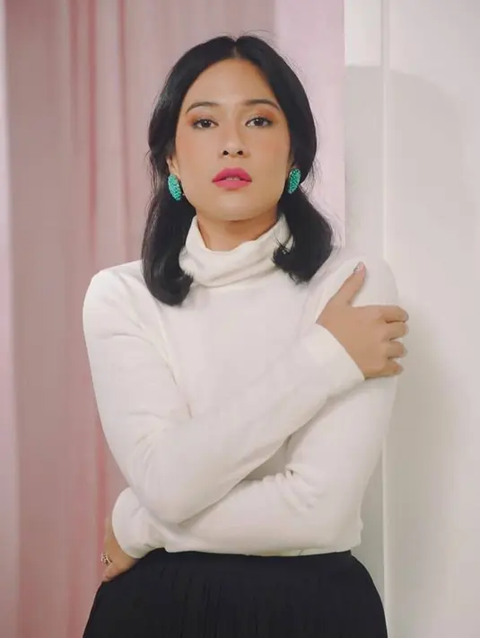 Gaya Dian Sastrowardoyo menggunakan busana model turtle neck berwarna putih yang dipadukan rok hitam juga bisa dijadikan inspirasi. Dalam penampilannya ini, wanita 38 tahun tersebut pun hanya memberikan detail aksesoris pada antingnya yang berwarna hijau. (Liputan6.com/IG/@therealdisastr)