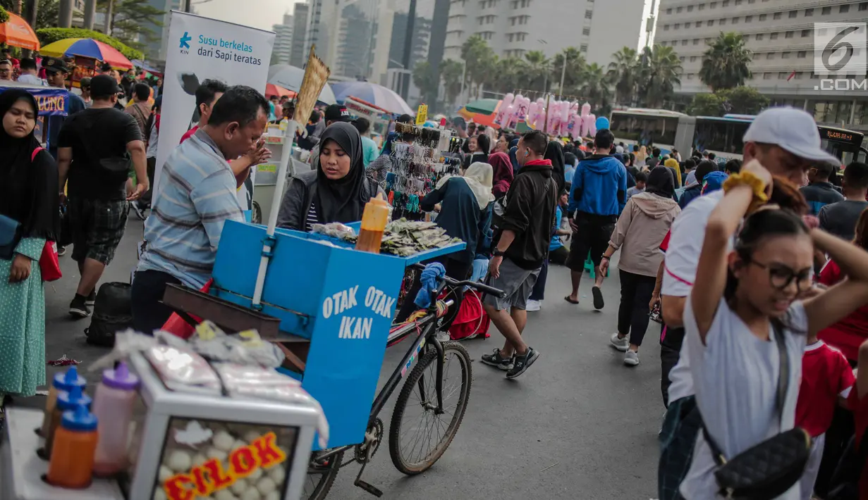Warga dan pedagang kaki lima (PKL) memadati kawasan car free day (CFD), Bundaran HI, Jakarta, Minggu (4/8/2019). Kurangnya pengawasan petugas menyebabkan banyak PKL berjualan tidak pada tempat yang telah disediakan oleh Pemprov DKI Jakarta. (Liputan6.com/Faizal Fanani)