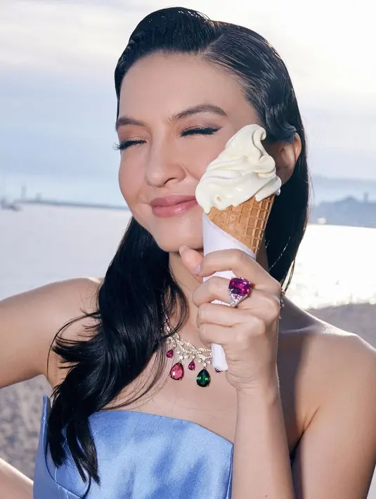 Rambutnya ditata dengan sleek look, biarkan tergerai bergelombang dan diambil ke satu sisi. Aksesori yang dikenakannya juga lebih berwarna; kalung dan cincin. Foto: Instagram.