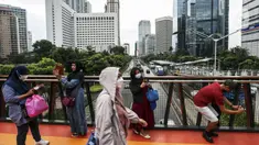 Warga berswafoto dengan kamera ponsel di Jembatan Penyeberangan Orang (JPO) Pinisi, Jalan Jenderal Sudirman, Karet, Jakarta, Selasa (15/3/2022). Belum lama ini, Pemprov DKI Jakarta meresmikan JPO berbentuk spesial tersebut yang membentang di atas Jalan Jenderal Sudirman. (Liputan6.com/Johan Tallo)