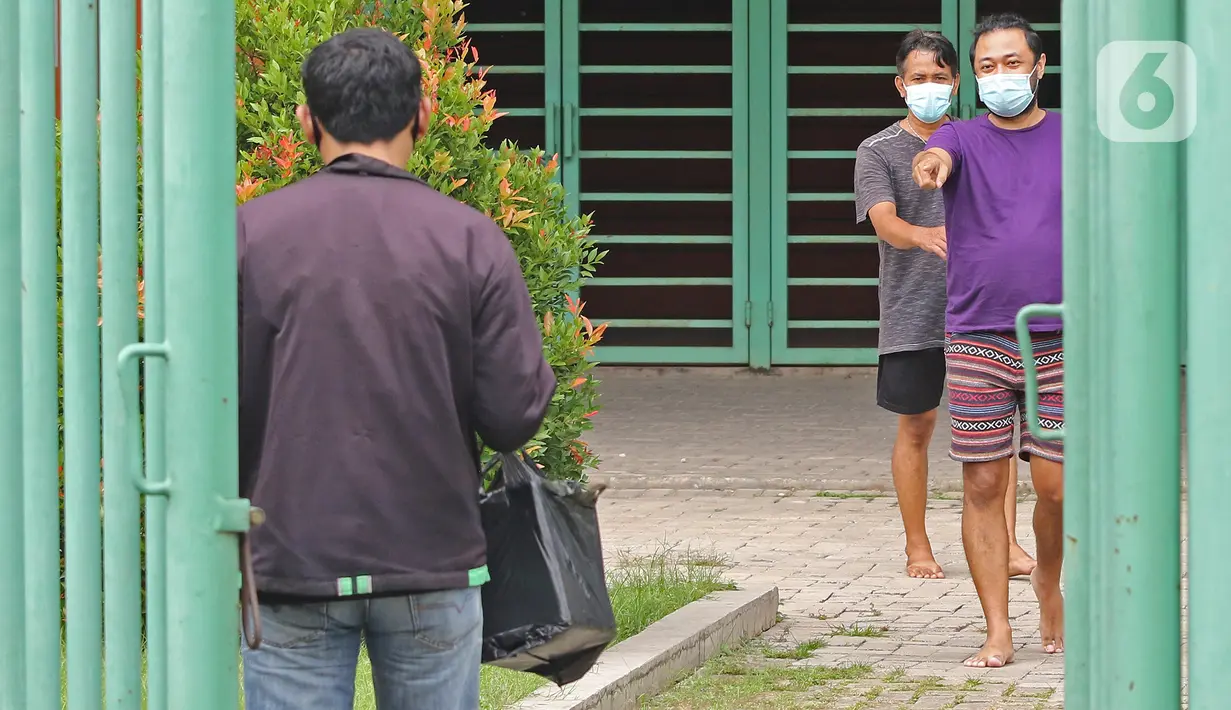 Pasien yang berstatus OTG saat mengambil paket seusai olahraga di Stadion Patriot Chandrabhaga, Bekasi, Jawa Barat, Rabu (16/12/2020). Kegiatan olahraga tersebut rutin dilakukan setiap pagi hari untuk meningkatkan daya tahan tubuh pasien yang menjalani isolasi mandiri. (Liputan6.com/Herman Zakharia)