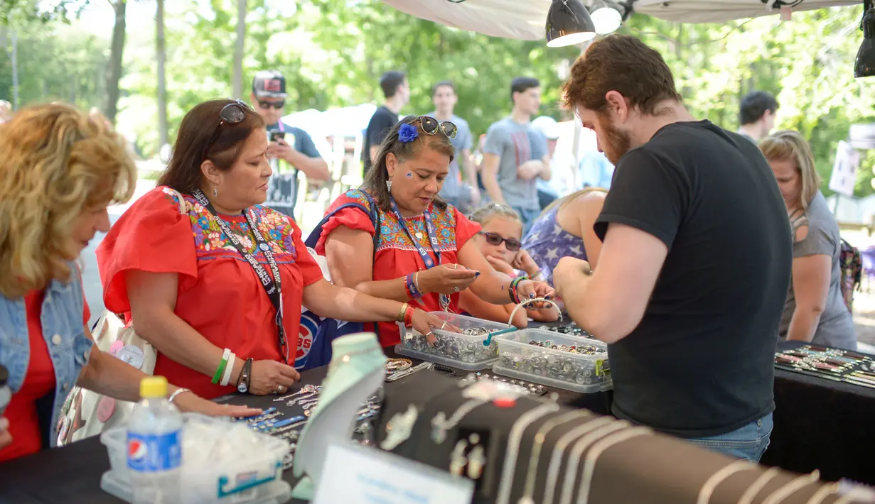 Anna Brickley (kiri) dan saudara kembarnya Blanco Tilly melihat perhiasan di sebuah stan saat Festival Twins Days tahunan ke-42 di Twinsburg, Ohio (5/8). Festival ini mengumpulkan orang-orang yang memiliki kembaran. (AFP Photo/Dustin Franz)
