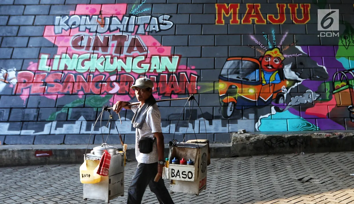Pengendara motor melintas di depan mural dan gravity di Kolong Tol, Jakarta, Rabu (19/6/2019). Pembuatan Mural Gravity tersebut bermaksud untuk membuat lingkungan sekitar menjadi indah dan elok dipandang mata. (Liputan6.com/Johan Tallo)