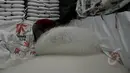 Pekerja saat mengemas beras di Pasar Induk Beras Cipinang, Jakarta, Selasa (24/2/2015). Harga beras sejak 9 Februari 2015 melonjak hingga 30 persen, hal ini disebabkan belum meratanya panen di daerah produsen. (Liputan6.com/Johan Tallo)
