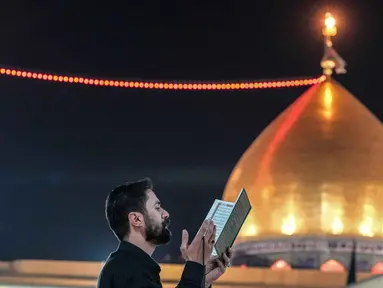 Seorang Muslim Syiah membaca Al-Quran, saat melaksanakan Itikaf di Masjid Kufa, selatan Baghdad, Irak, pada 12 Maret 2026. (Qassem al-KAABI/AFP)