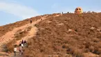 Orang-orang mengunjungi Pumpkin Rock (Batu Labu) di puncak sebuah bukit di Norco,  California, AS (18/10/2020). Menjelang perayaan Halloween, Pumpkin Rock, sebongkah batu raksasa yang dilukisi seperti Jack-O'-Lantern besar, menjadi objek wisata yang populer bagi pengunjung. (Xinhua/Gao Shan)